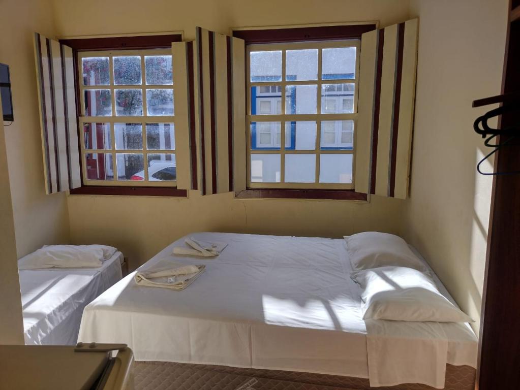迪亚曼蒂纳Pousada Ouro de Minas的一间卧室设有两张床和两个窗户。