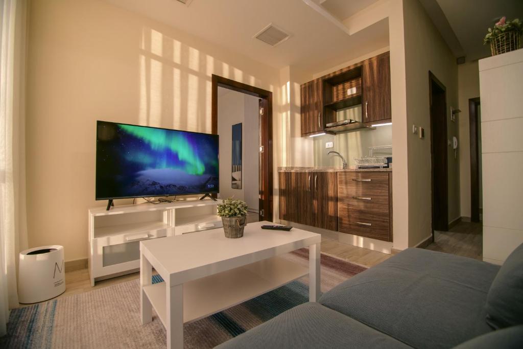 安曼46 Serviced Apartments的客厅配有电视和白色咖啡桌。