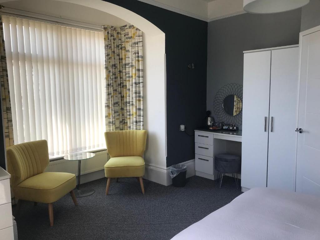 尚克林圣莱昂纳茨旅馆的一间卧室配有一张床、两把椅子和一张书桌