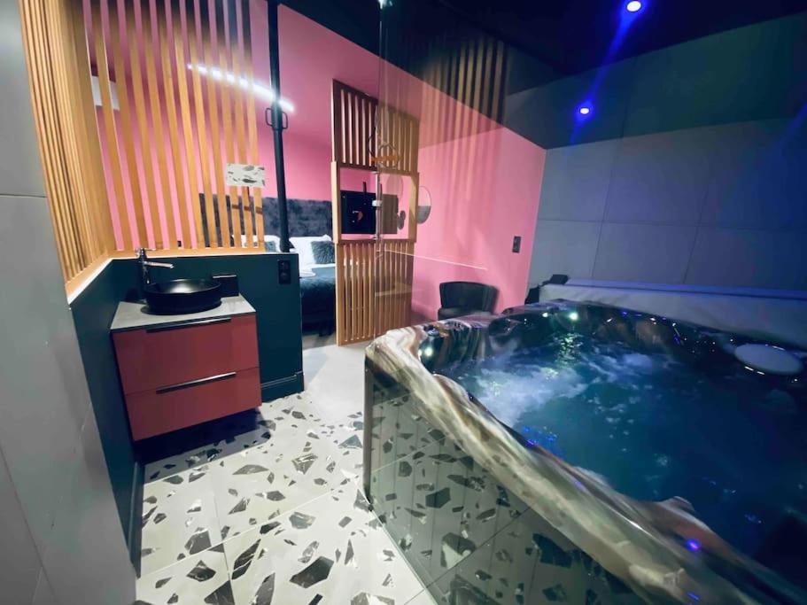 波尔多La Litchi Le 50 Suites and Spa centre ville的一间带大浴缸和水槽的浴室