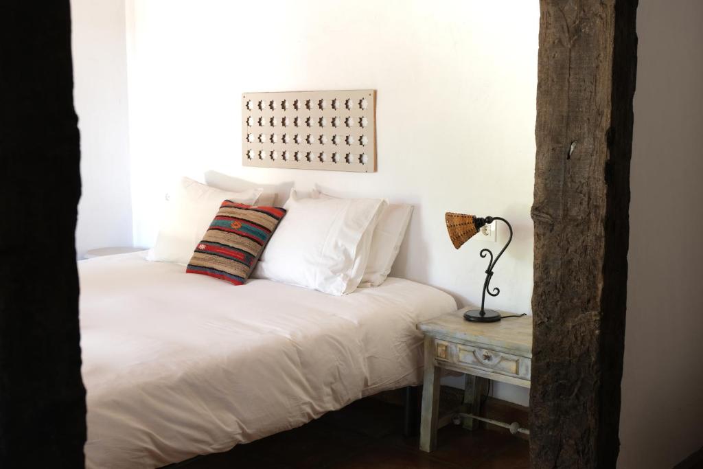 卡萨雷斯The Wild Olive Andalucía Agave Guestroom的一张带白色床单的床和一张桌子上的台灯