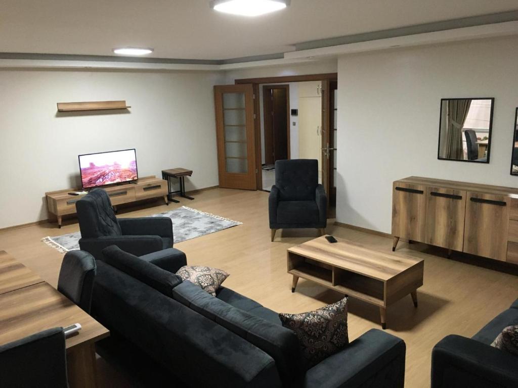 شقه طرابزون的客厅配有沙发、椅子和平面电视。