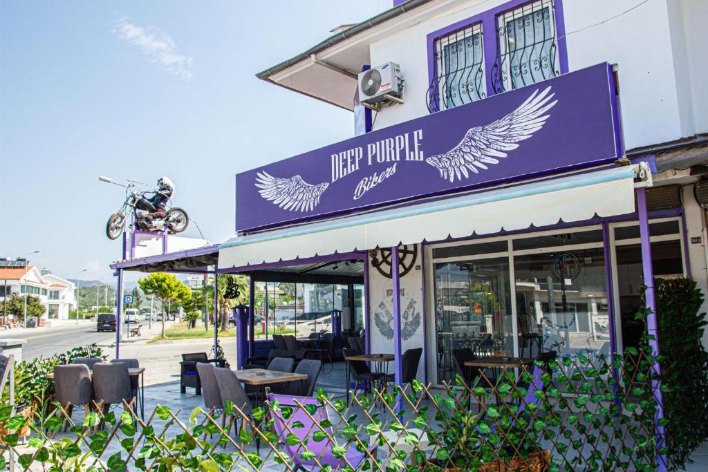 费特希耶Deep Purple Bikers的一间有紫色标志的餐厅,上面有鸟儿