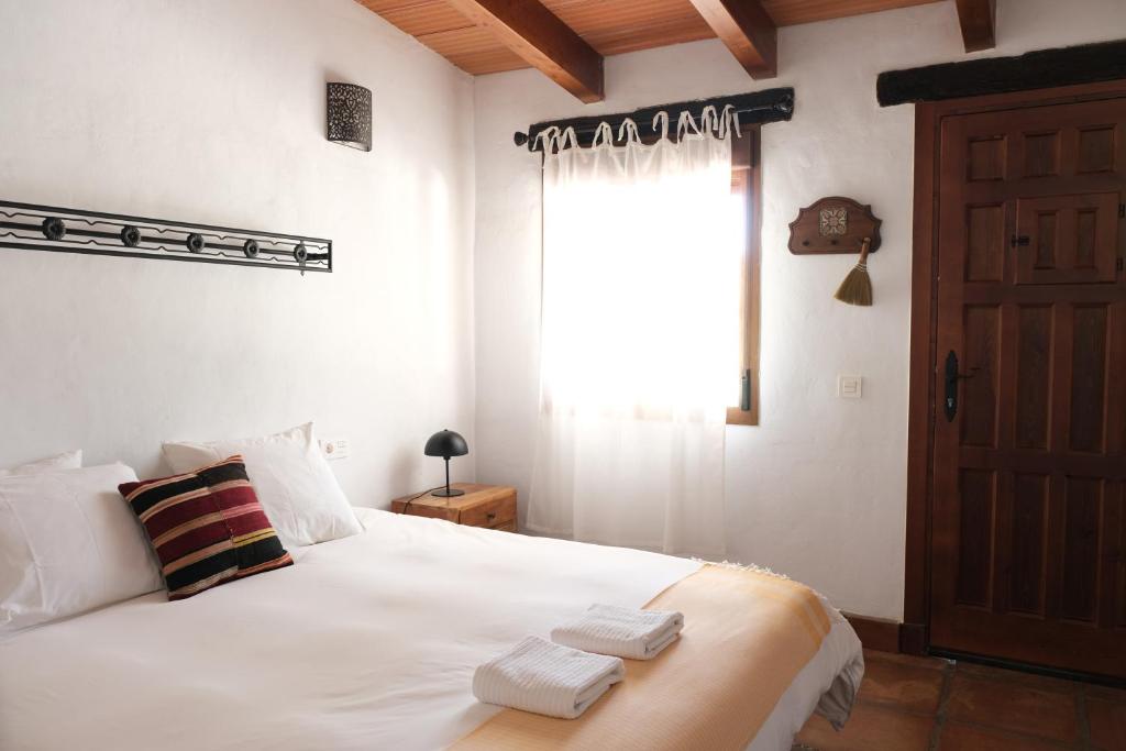 卡萨雷斯The Wild Olive Andalucía Palma Guestroom的卧室配有白色床和毛巾