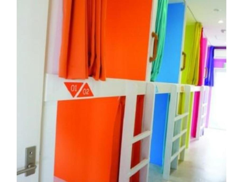 神户GuestHouse Geragera - Vacation STAY 95129v的一间拥有色彩缤纷的墙壁和色彩缤纷的架子的房间
