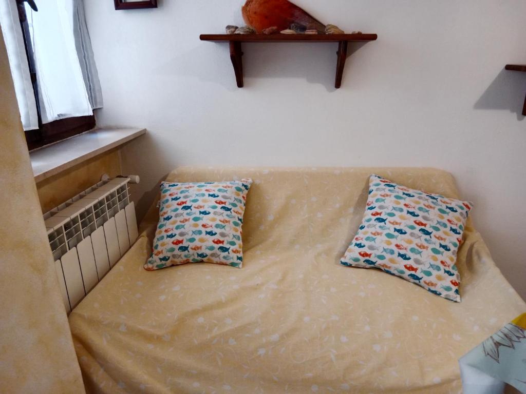 Isola del GiglioCasa girasole的两个枕头坐在房间里沙发上