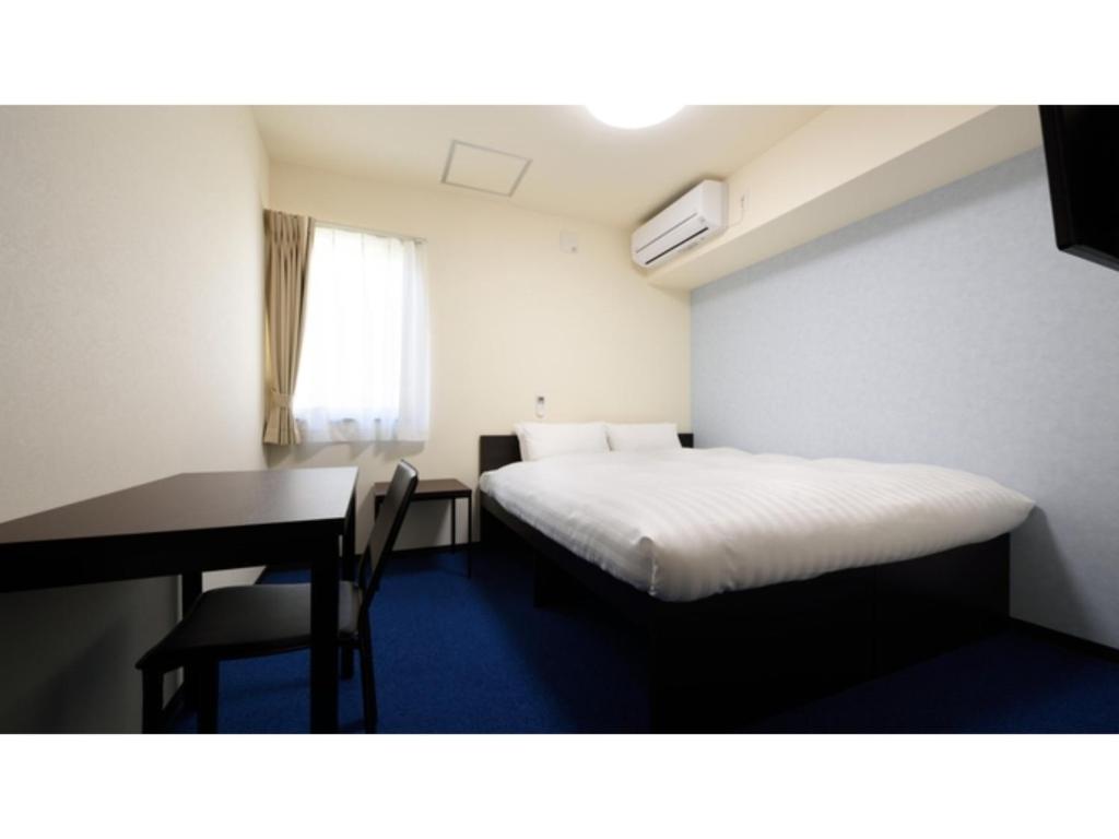 气仙沼市La'gent Inn Kesennuma - Vacation STAY 85808v的小房间设有一张床、一张桌子和一张桌子