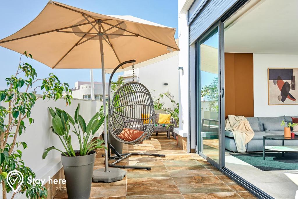 拉巴特Stayhere Rabat - Agdal 3 - Prestige Residence的一个带秋千和遮阳伞的庭院