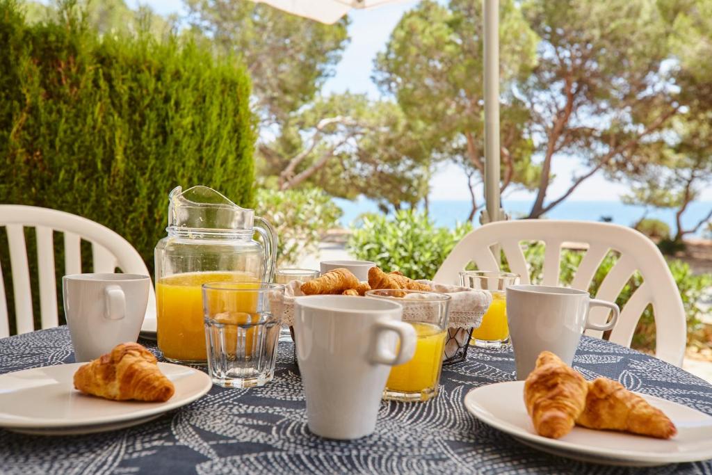 卡拉法特La mejor vista al mar !!!的一张桌子,上面放着羊角面包和橙汁