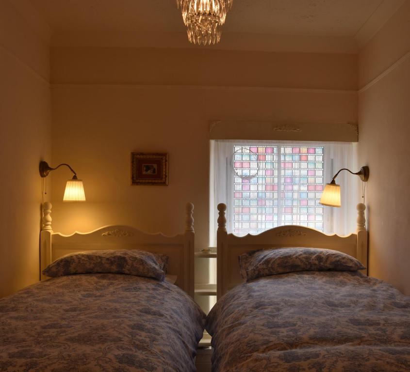 TreharrisY Bwthyn Bach - Taff Trail的卧室设有两张床,带窗户