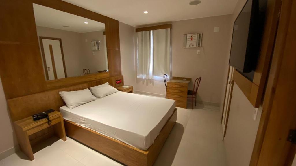 里约热内卢Verona Hotel的一间小卧室,配有一张床和电视