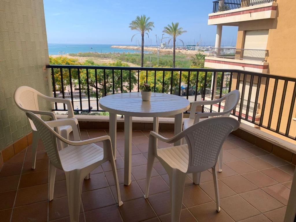塞古德卡拉斐Apartamento Primera Línea de Playa Port-Segur的海滩阳台的桌椅
