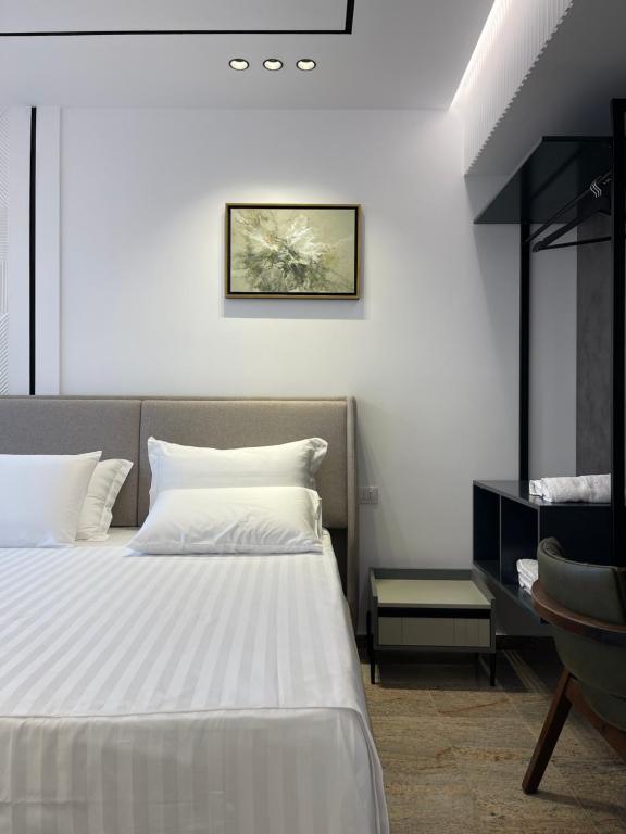 维利波吉Olivea Apartments的卧室配有白色的床和书桌