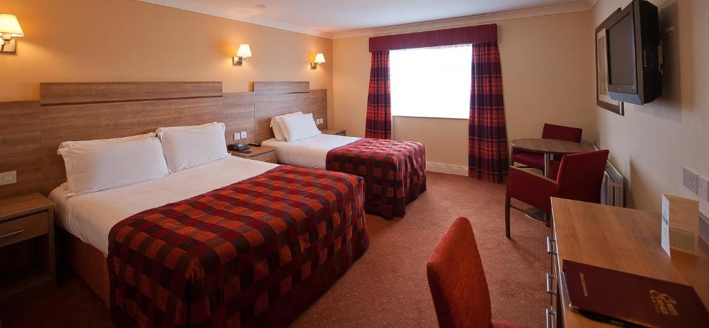 纽敦阿比可儿之角酒店的酒店客房设有两张床和电视。
