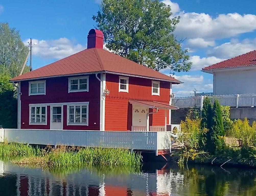 AsarumLovely Waterfront Cottage near Karlshamn的河边的红房子