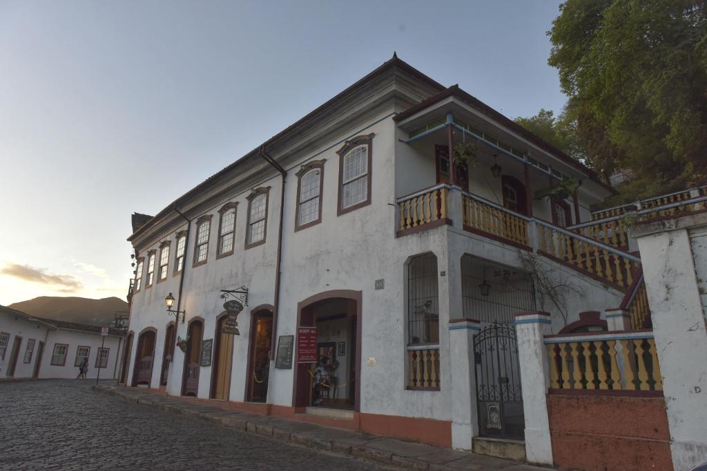 欧鲁普雷图Casa do Chá Ouro Preto的街道上带阳台的白色建筑