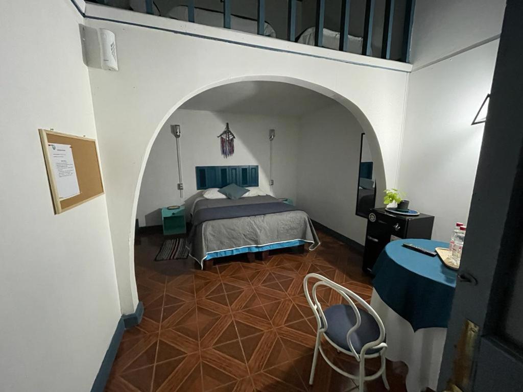 圣地亚哥ICCE HOTEL的卧室配有1张床、1张桌子和1把椅子