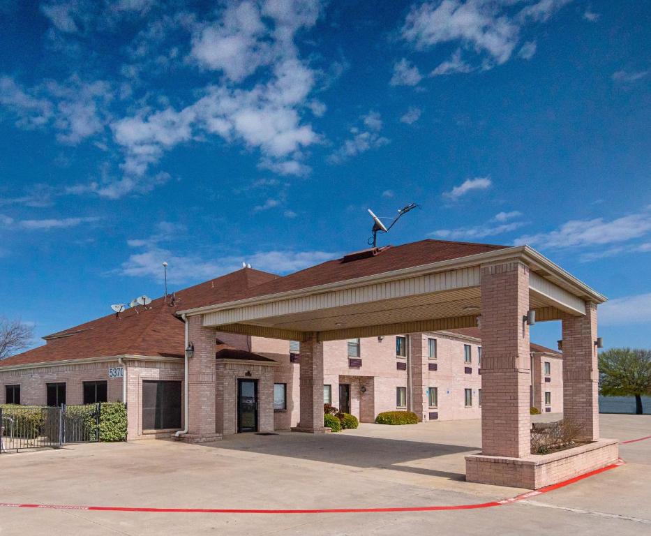 沃思堡Red Roof Inn Fort Worth - Saginaw的一座建筑的顶部有风力涡轮机