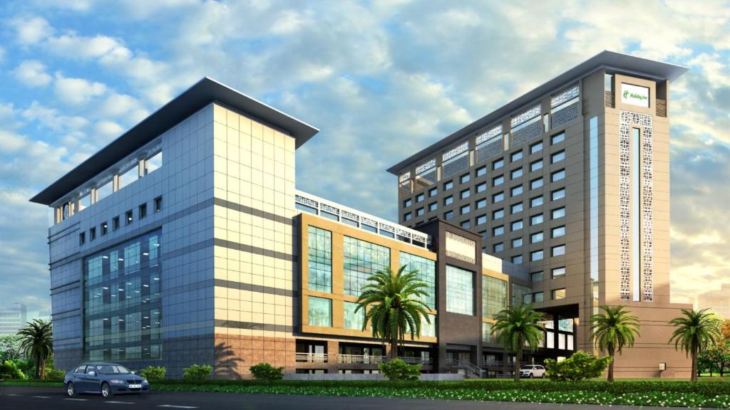 钱德加尔Holiday Inn Chandigarh Zirakpur, an IHG Hotel的前面有停车位的建筑