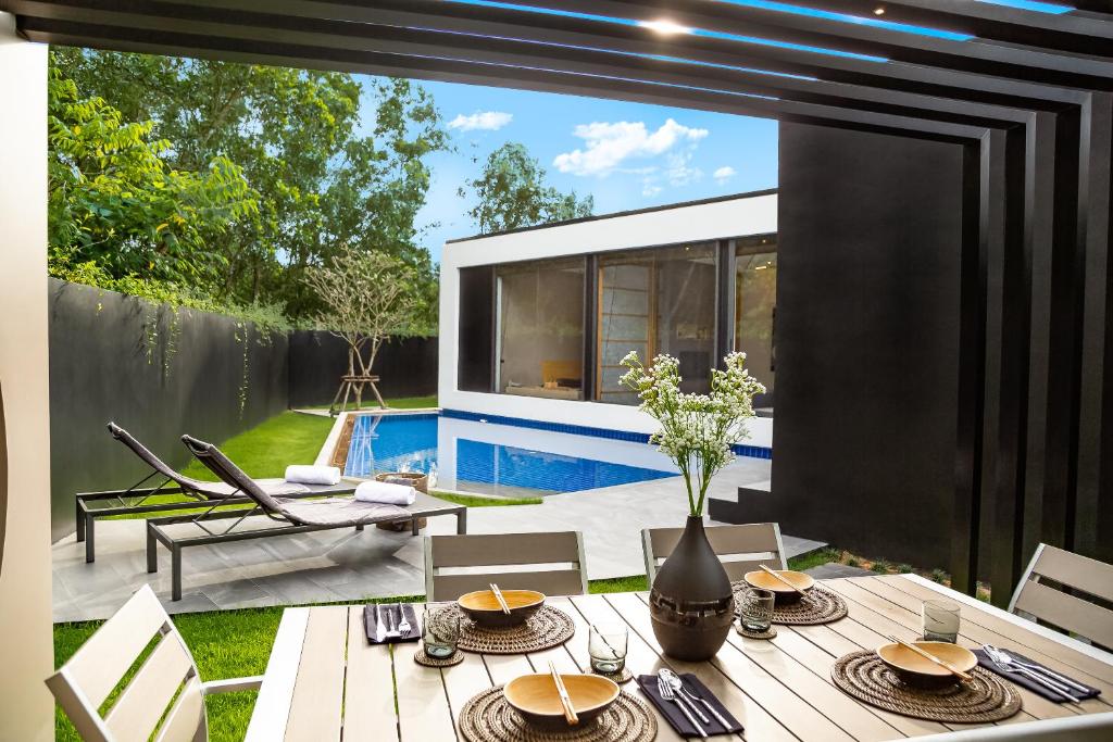 他朗Villoft Zen Living Resort的一个带桌子和游泳池的庭院