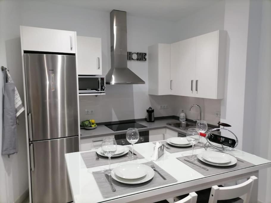 麦地那西多尼亚Precioso apartamento con patio interior.的厨房配有白色橱柜和不锈钢冰箱