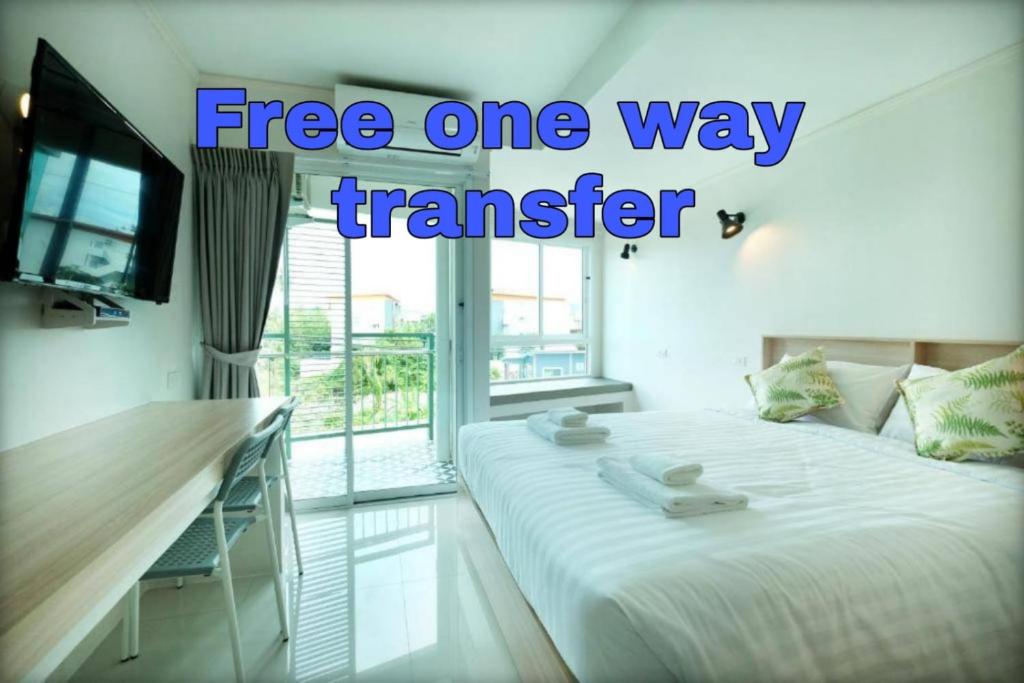 奈扬海滩beHOME Phuket的一间房间,配有一张床和一台带字样的免费单程交通服务的电视