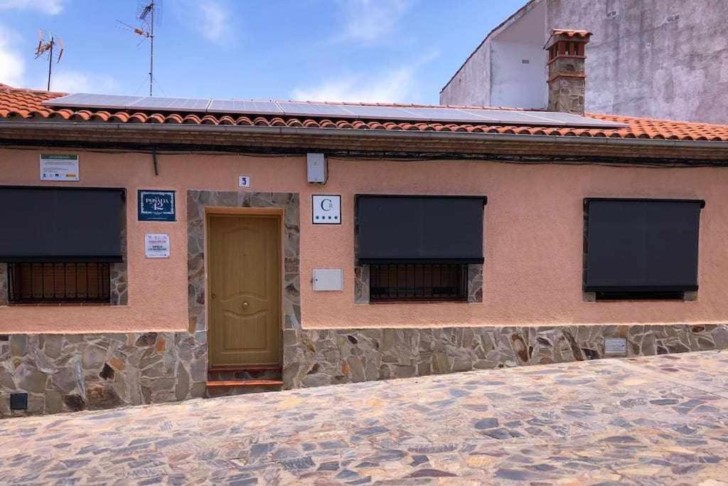 CarrascalejoCasa Rural La Posada del 42的一座带棕色门和两扇窗户的建筑
