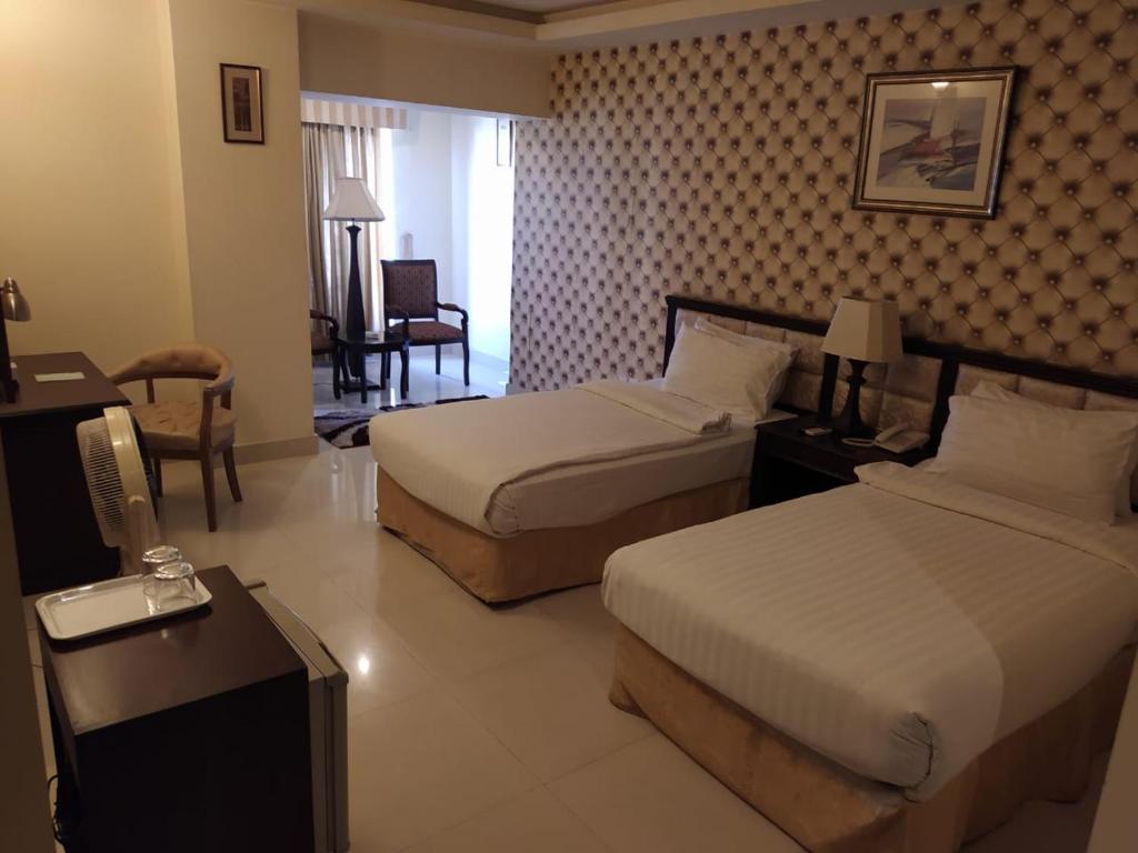 拉希迈尔汗Royal Desert Palm Hotel的酒店客房配有两张床和一张书桌