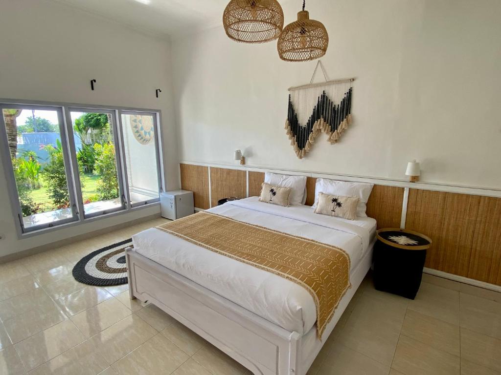 乌鲁瓦图Bella Bali的卧室设有一张白色大床和两个窗户。