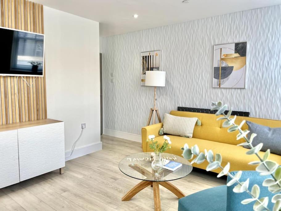 波斯考尔New Seaside Apartment 2 Porthcawl的客厅设有黄色沙发和玻璃桌