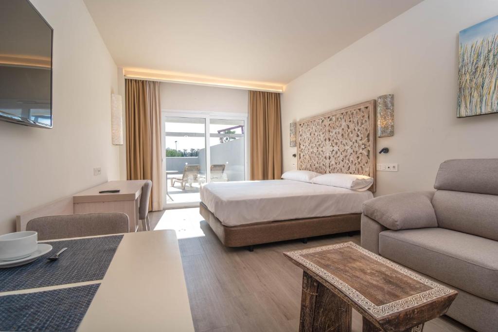 GelvesAljarafe Suites by QHotels的酒店客房,配有床和沙发