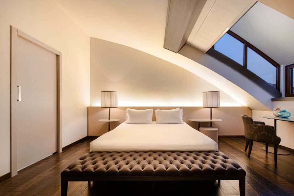 穆拉诺Hyatt Centric Murano Venice的一间卧室配有一张床,其中配有长凳