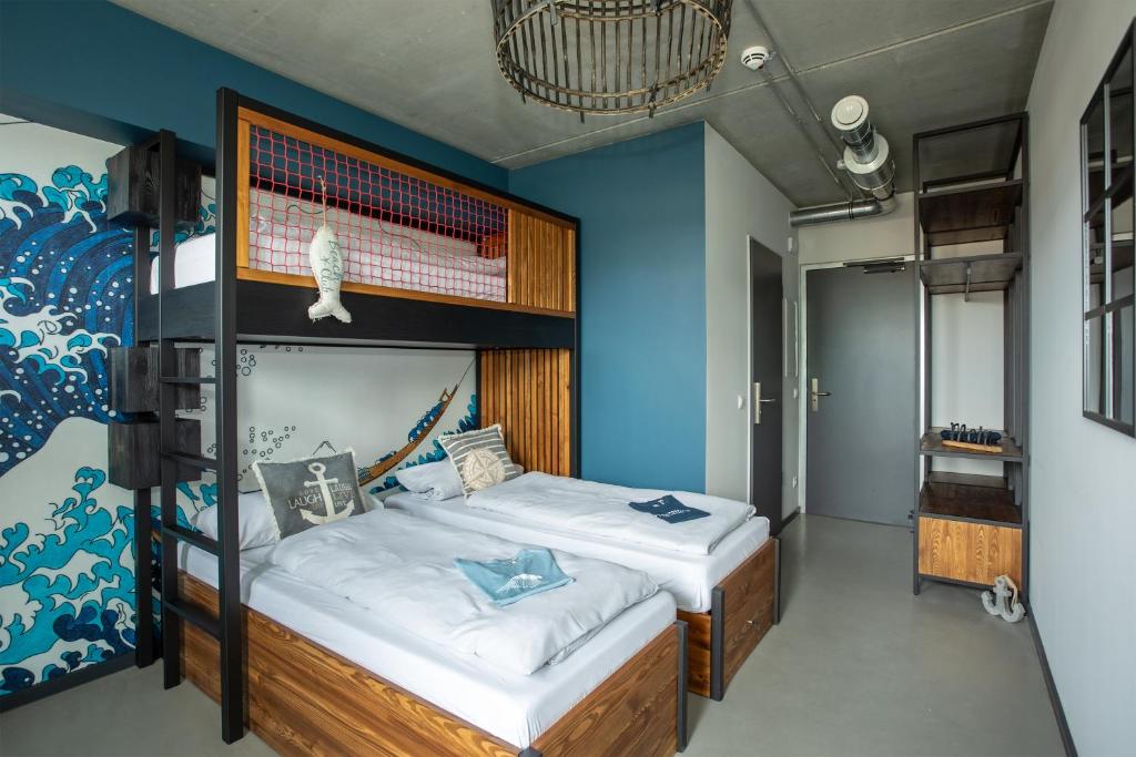 格洛米茨Surf Rescue Club的一间卧室设有两张双层床和蓝色的墙壁