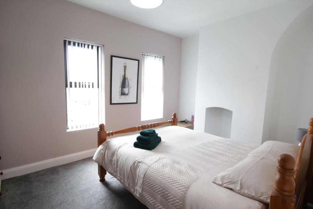 贝尔法斯特House in the Gaeltacht Quarter的一间卧室,配有一张带绿色帽子的床