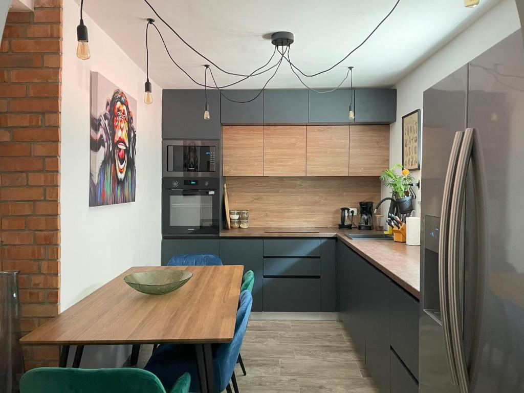 诺维·维诺多尔斯基B&D的厨房配有木桌和冰箱。