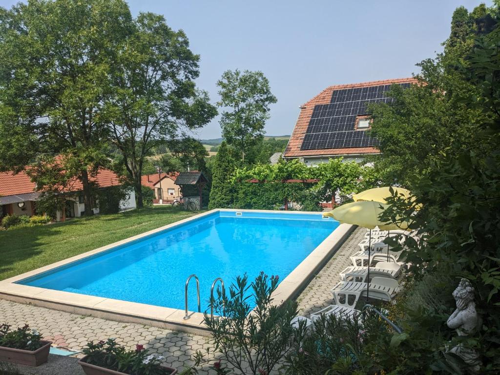 锡尔沃斯瓦里德Guest house Magyar Route 66的一个带太阳能屋顶的庭院内的游泳池