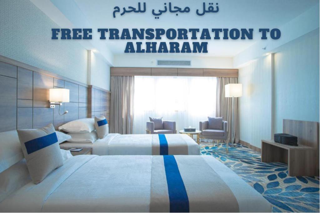 麦地那Season Star Hotel Madinah的酒店客房设有两张床和一个标志,上面写着免费前往Almingham的交通工具
