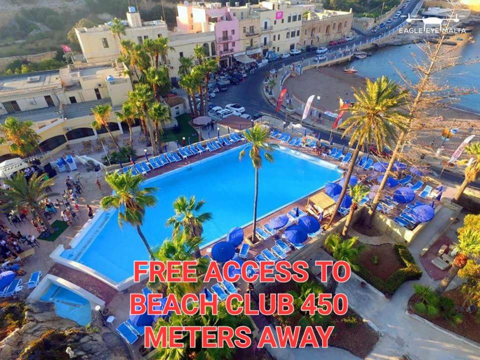 圣朱利安斯Antoniel Suites的享有距离度假酒店数米的海滩俱乐部的游泳池景致