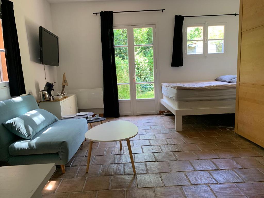 圣特罗佩le calme chambre 2的带沙发、床和桌子的客厅
