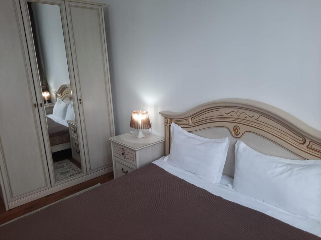 塔尔迪库尔干Апарт отель Welcome的一间卧室配有一张带白色枕头和镜子的床
