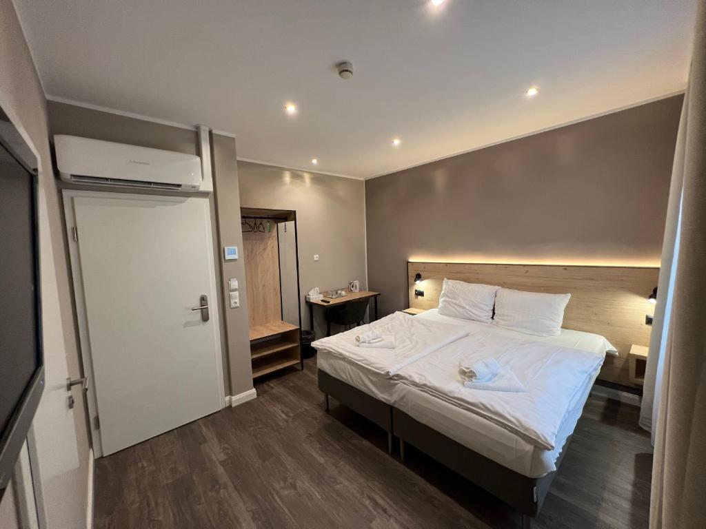 汉诺威JJ Hotel Hannover-City-Pension的一间卧室配有一张带白色床单的大床