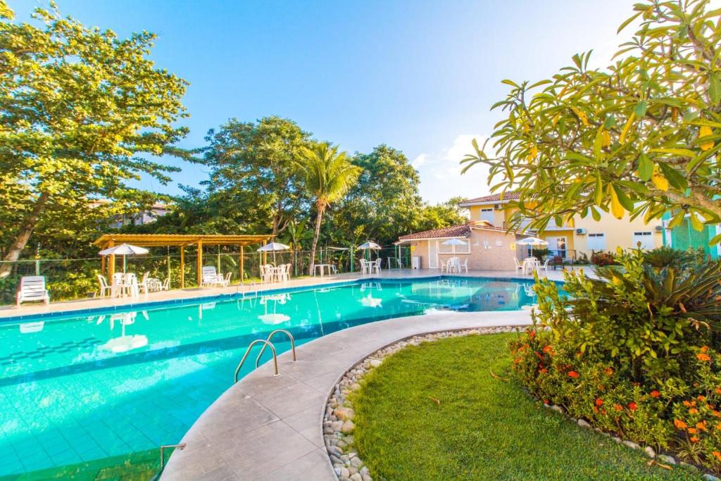 塞古罗港Apart Hotel Boulevard da Praia - Portal Hotéis的庭院内一个带椅子和树木的游泳池