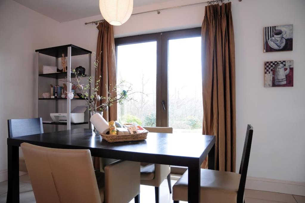 基拉尼Killarney , Ring of Kerry 2 Bed Apartment 2 Bathrooms的一间用餐室,配有黑色的桌子和椅子