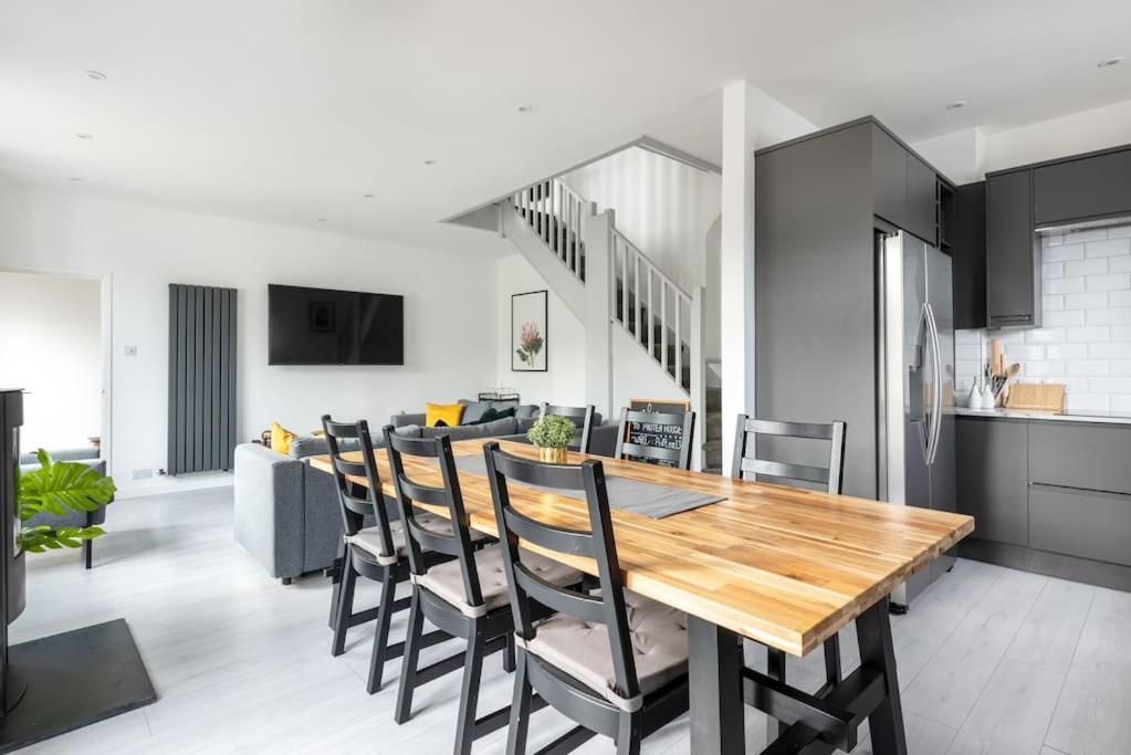 纽基Spacious, Modern Home, Central Newquay w/ parking的厨房以及带木桌和椅子的用餐室。