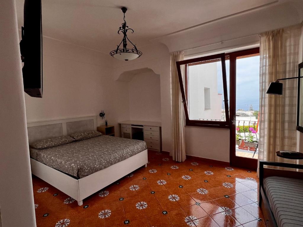 阿纳卡普里Casa Dora的一间卧室设有一张床和一个大窗户