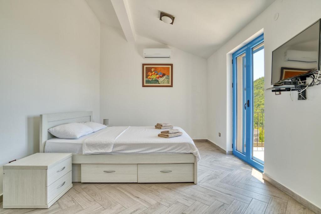 布德瓦Villa Old Olive的白色的卧室设有床和窗户