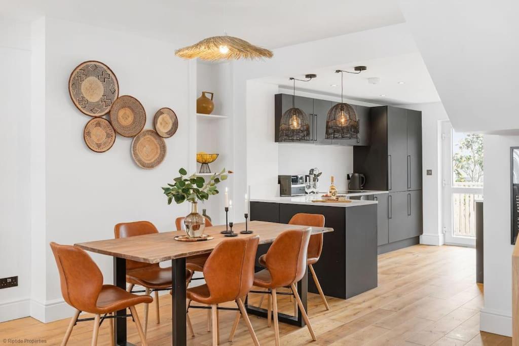 纽基Stylish & Modern Home, Central Newquay w/parking的厨房以及带桌椅的用餐室。