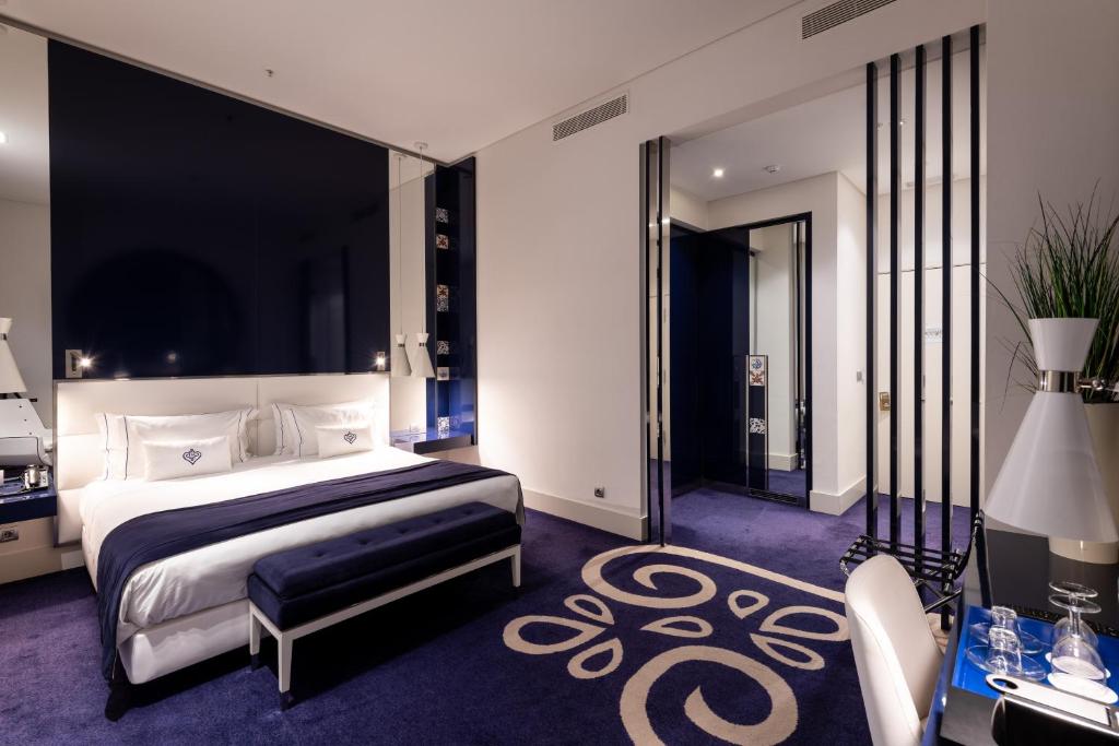 里斯本葡萄牙精品酒店的一间卧室配有一张特大号床和一张书桌