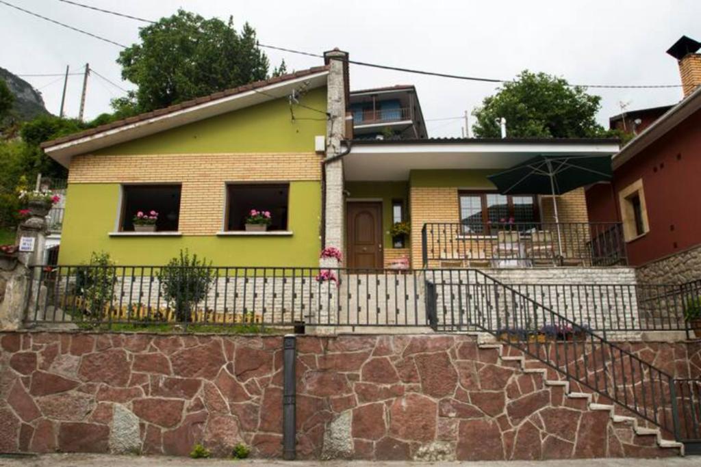 卡瑞纳Casa La Bolera的黄色的房子,有栅栏和石墙