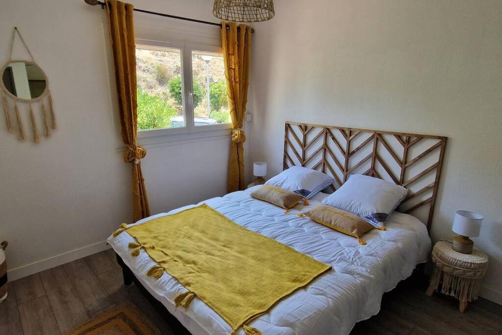 科利尤尔Charmant T3 en bord de mer的一间卧室配有一张黄色毯子床